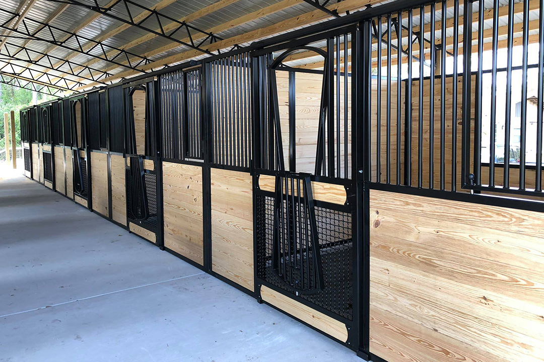 Open yoke stall doors on the exterior of a horse barn